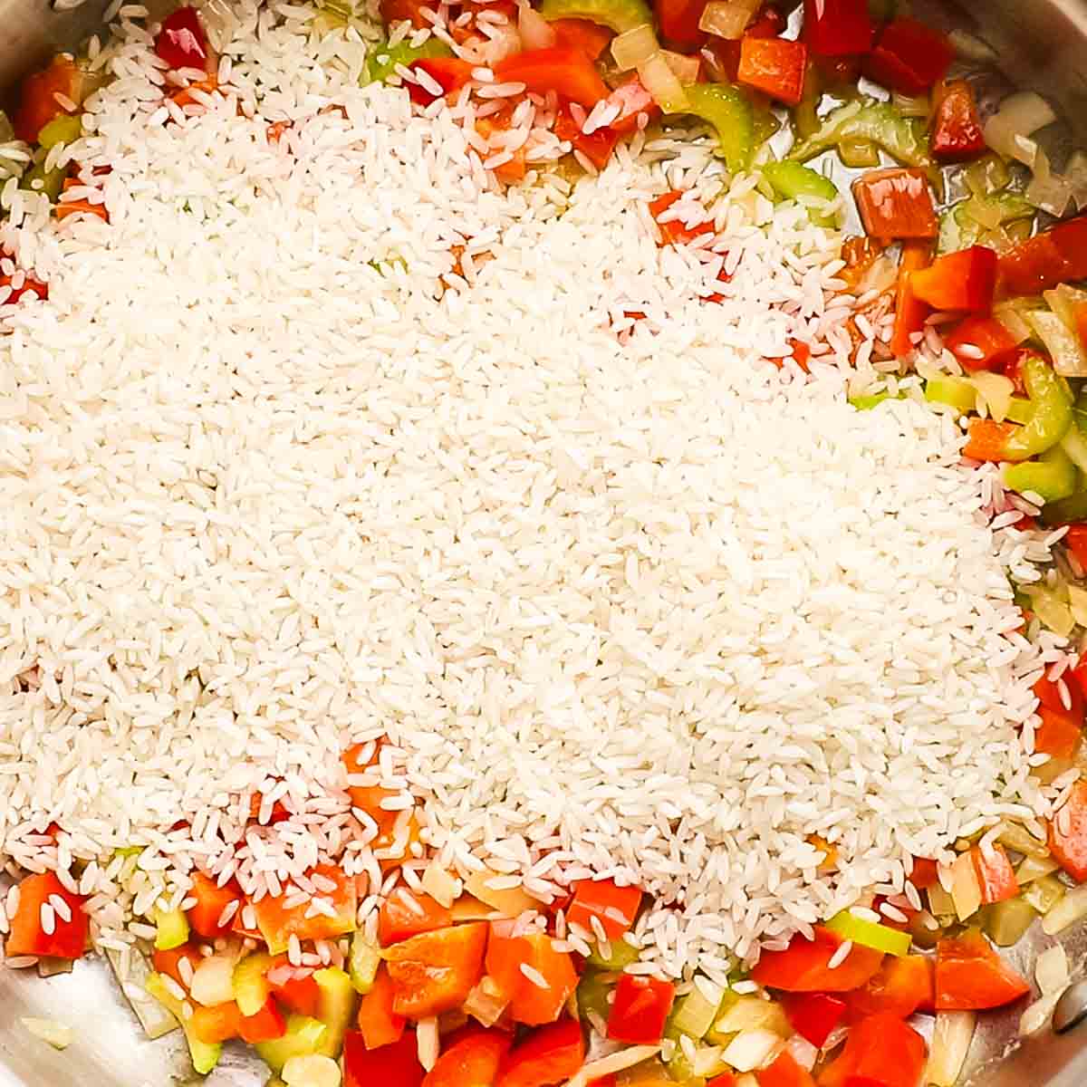 adding rice to the vegetables