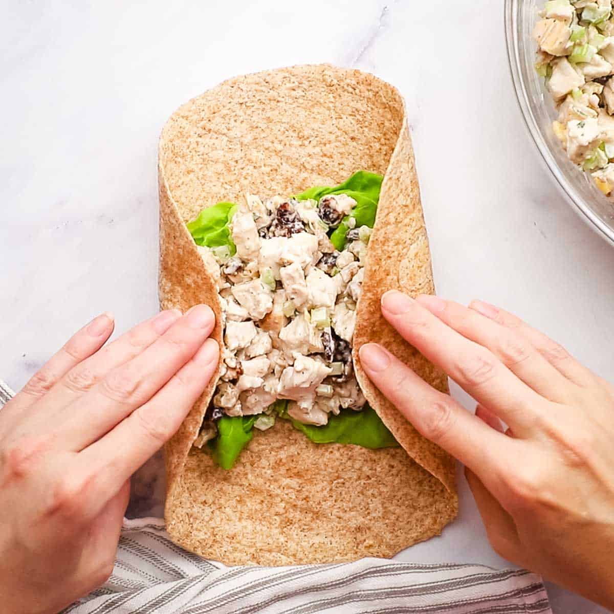 folding in the sides on the chicken salad