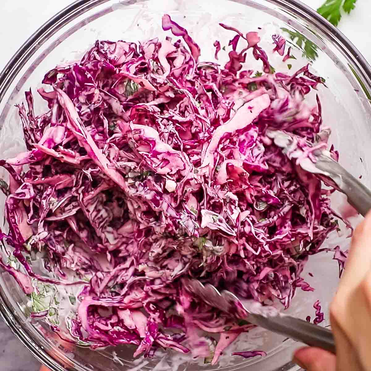 tossing the cabbage in the creamy mixture