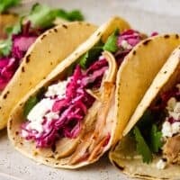 chicken tacos with cilantro lime slaw served on a plate.