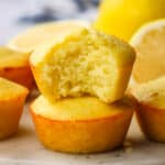 Two muffins stacked on top of each other with a bite taken out of the top one.