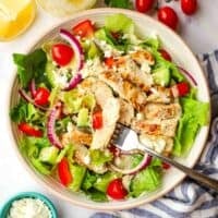 an overhead view of greek chicken salad on a plate