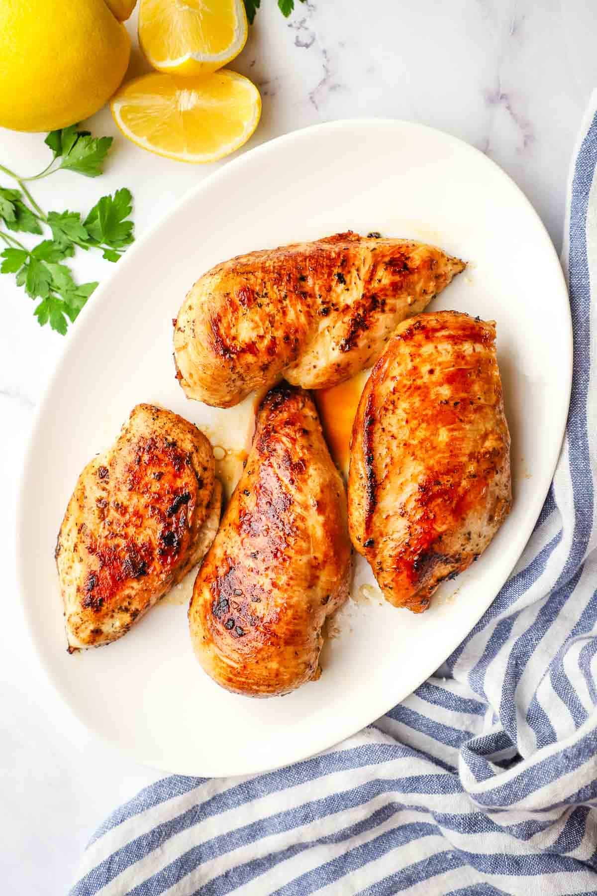 cooked greek marinated chicken breasts on a plate.