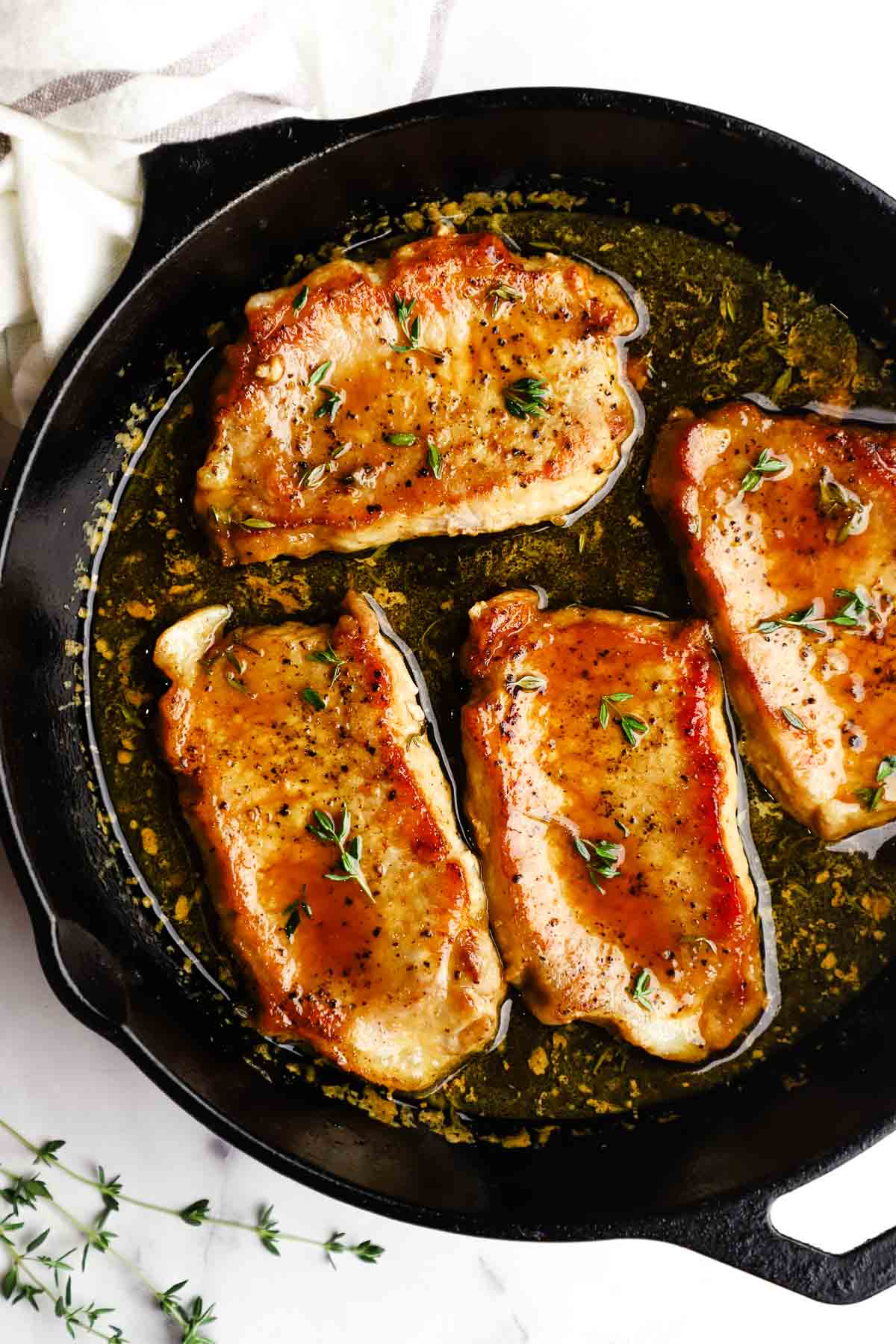 overhead view of maple glazed pork chops in a cast iron skillet