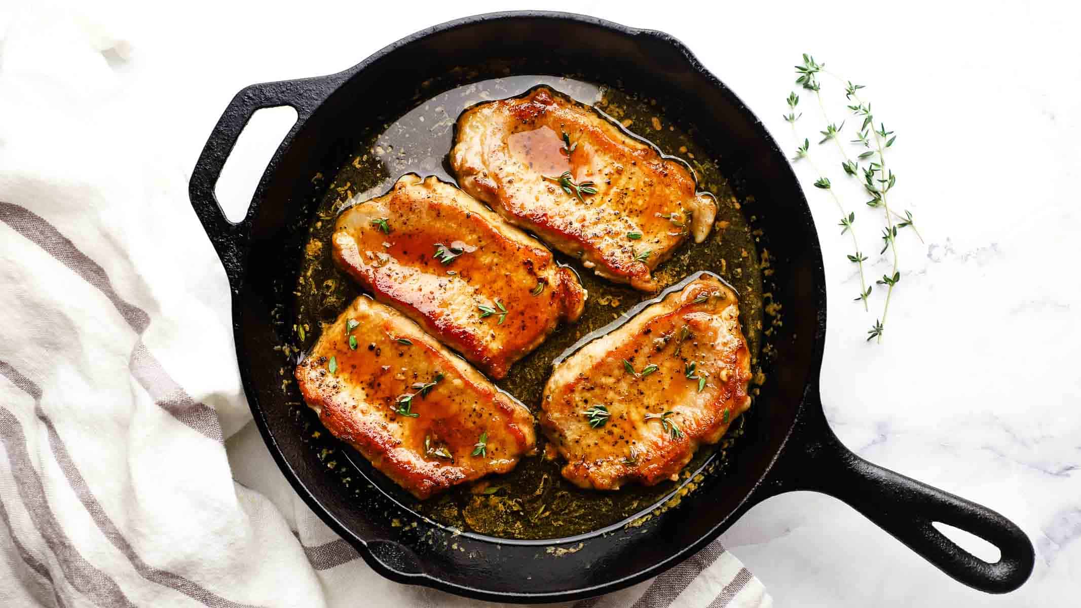 maple glazed pork chops in a cast iron skillet