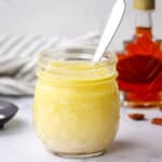 A jar of homemade vinaigrette with a spoon in it.