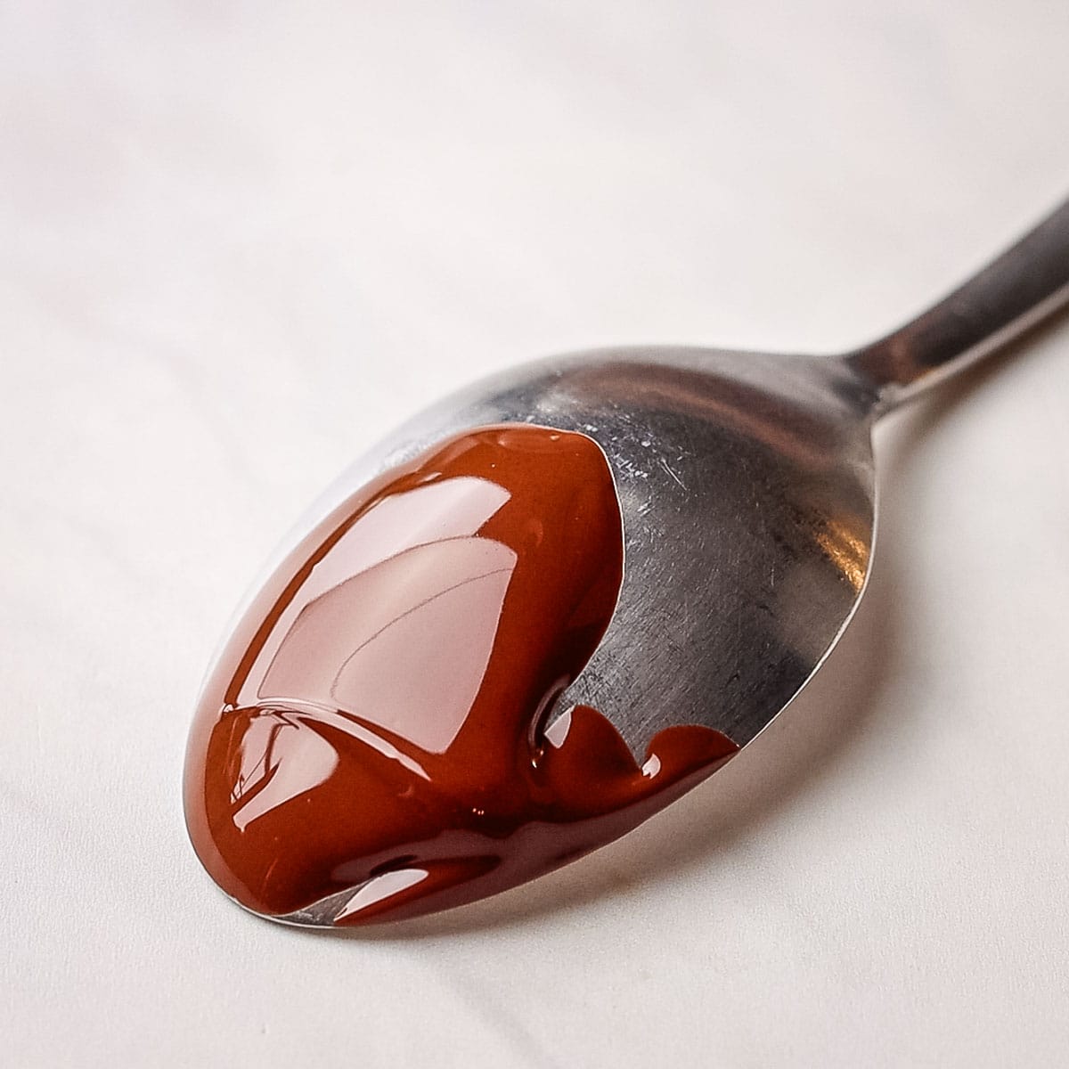 A spoon dipped in melted chocolate to test the temper.
