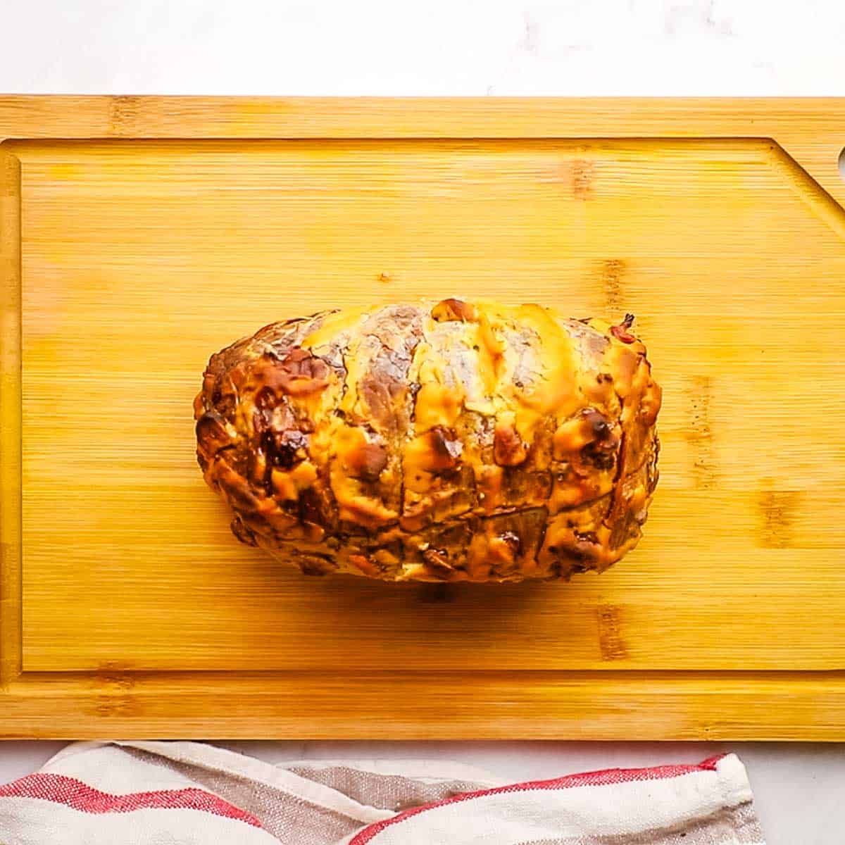 roasted top round roast beef placed on a cutting board