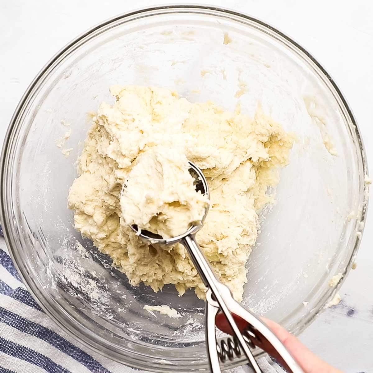 scooping out biscuit dough with a cookie scoop