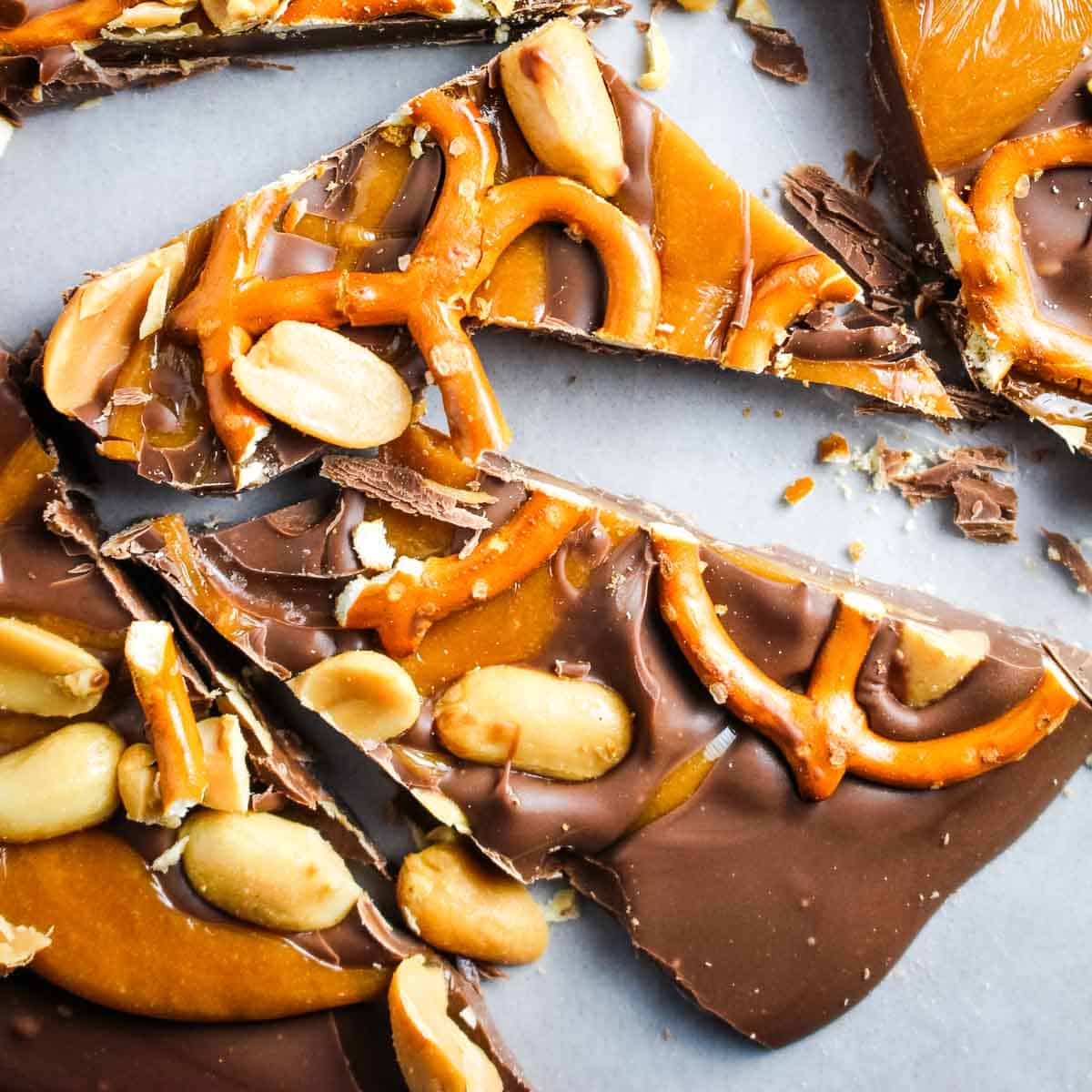 Pieces of chocolate bark with pretzels, peanuts and caramel.