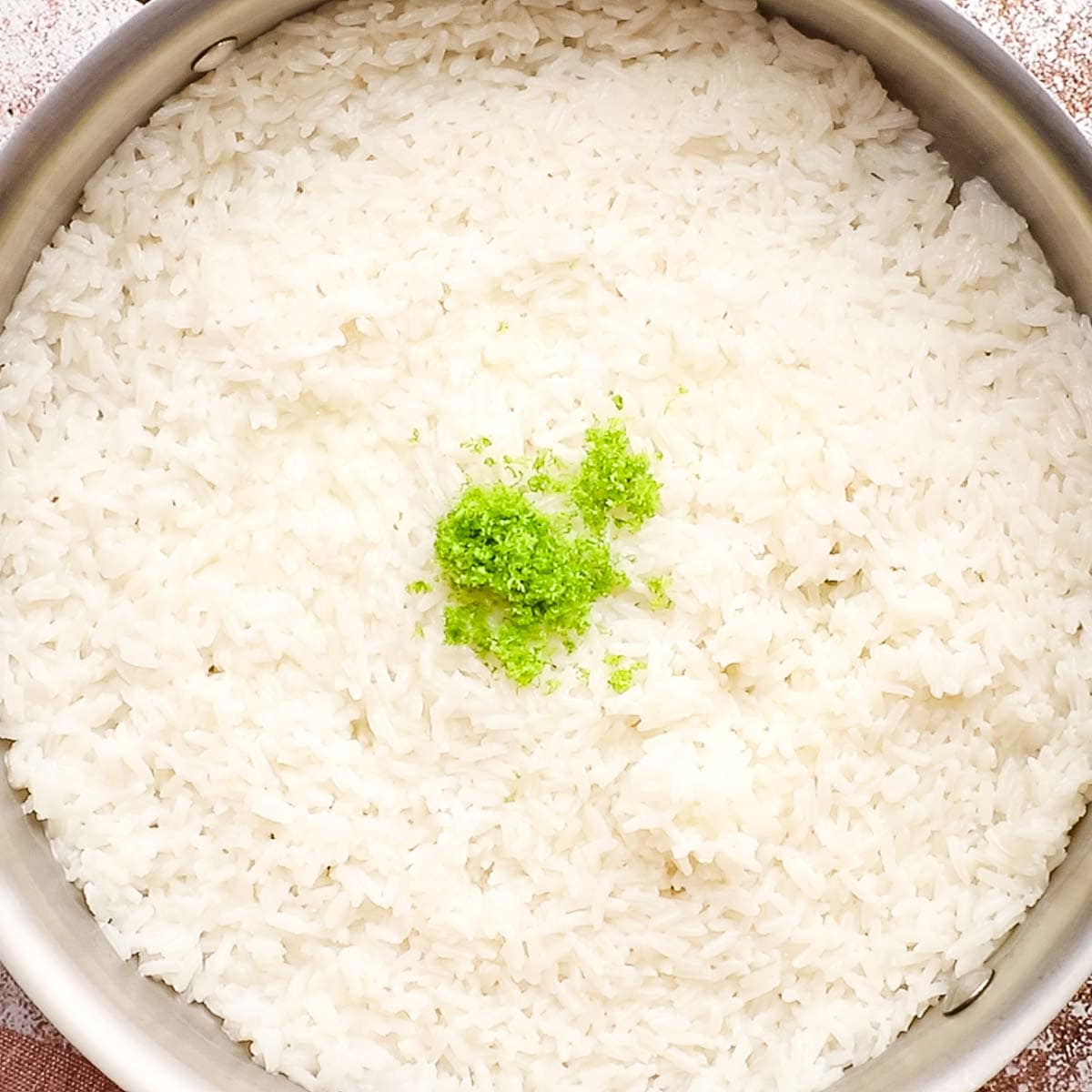 baked coconut rice in a dish topped with cilantro leaves
