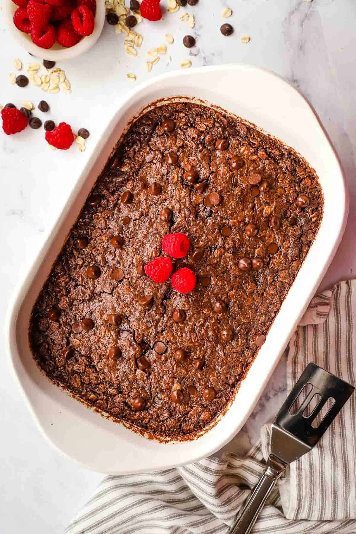 a dish of chocolate baked oats topped with fresh raspberries