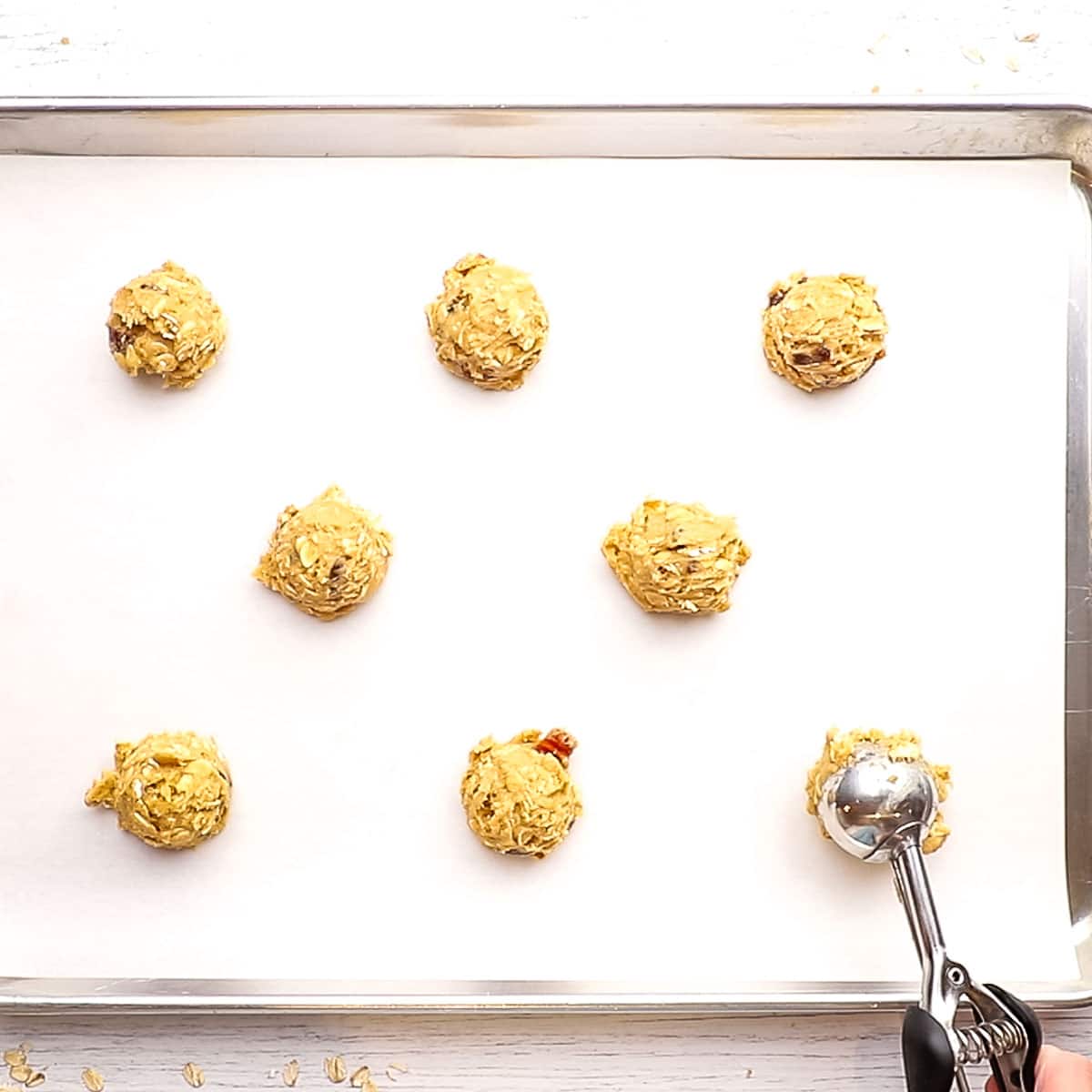 cookie dough balls lined on a baking sheet