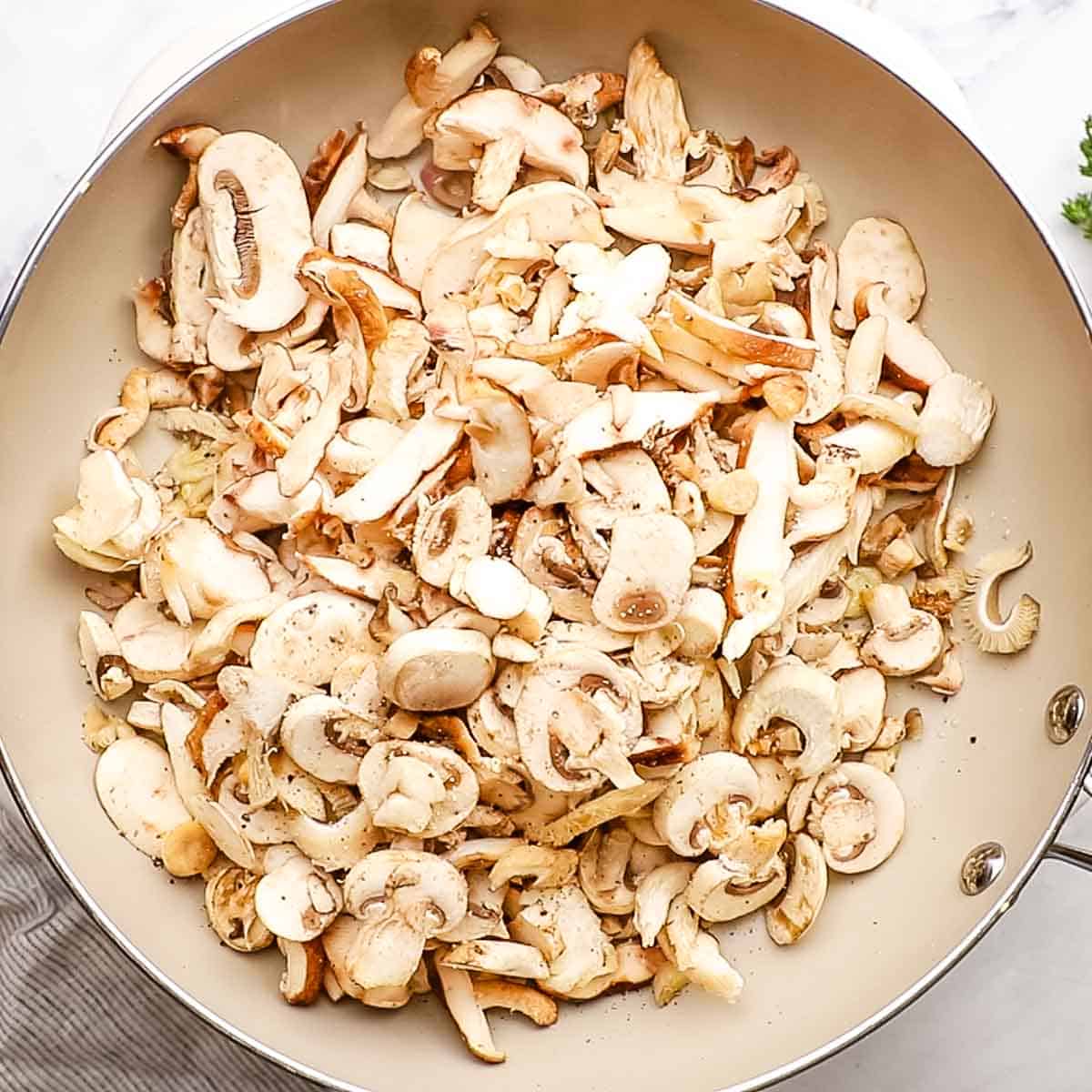 sliced mushrooms added to the pan