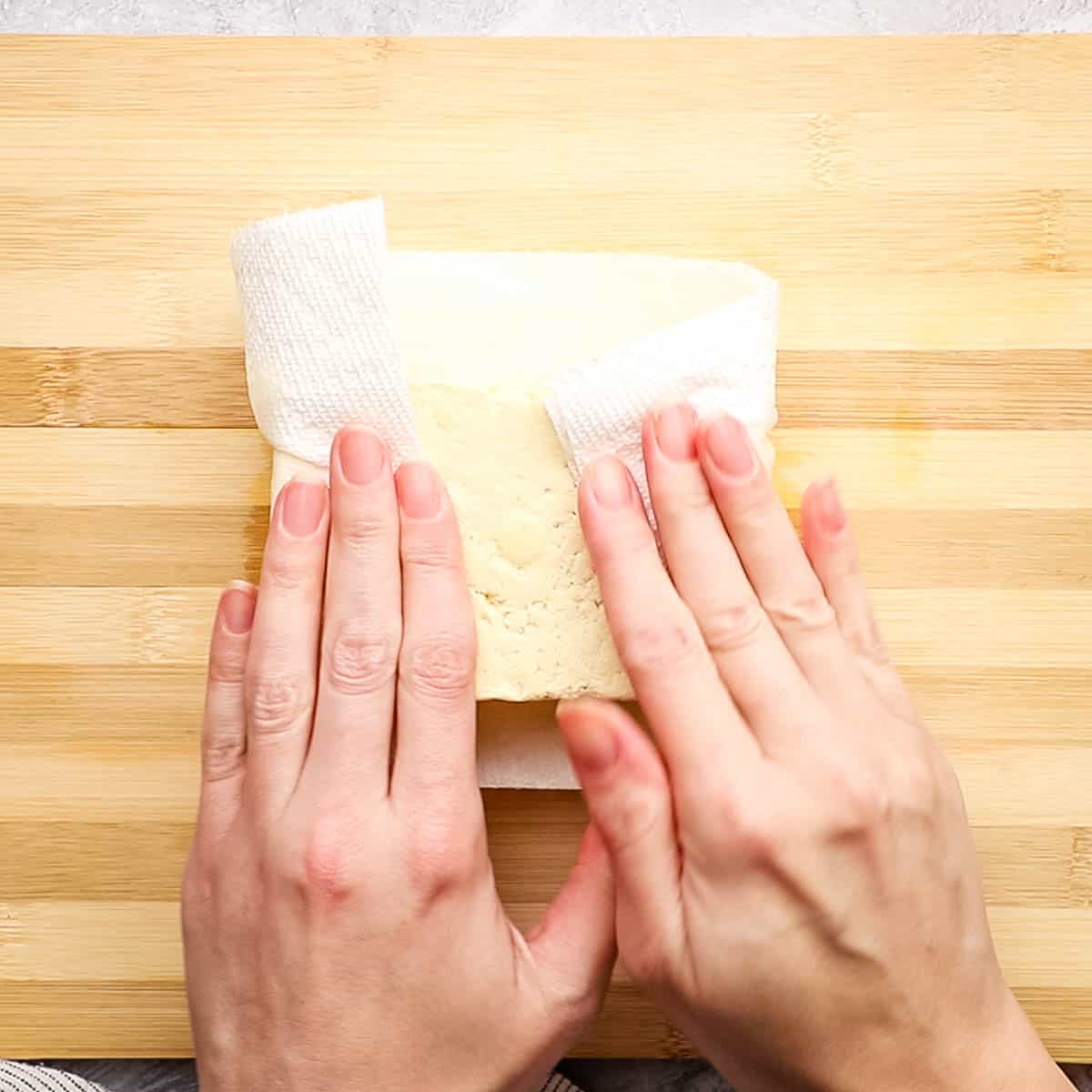 pressing tofu blocks between paper towel