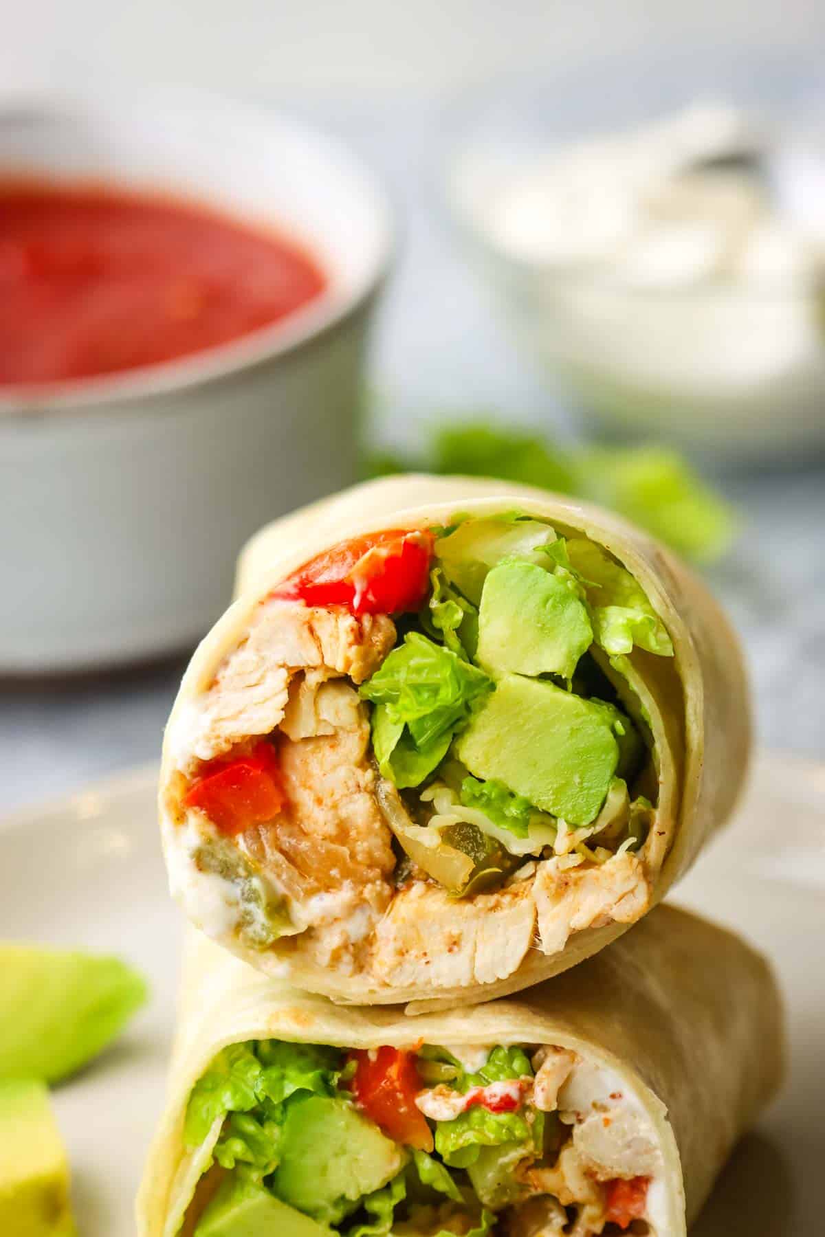 Two halves of a chicken fajita wrap stacked on top of each other to show the filling.