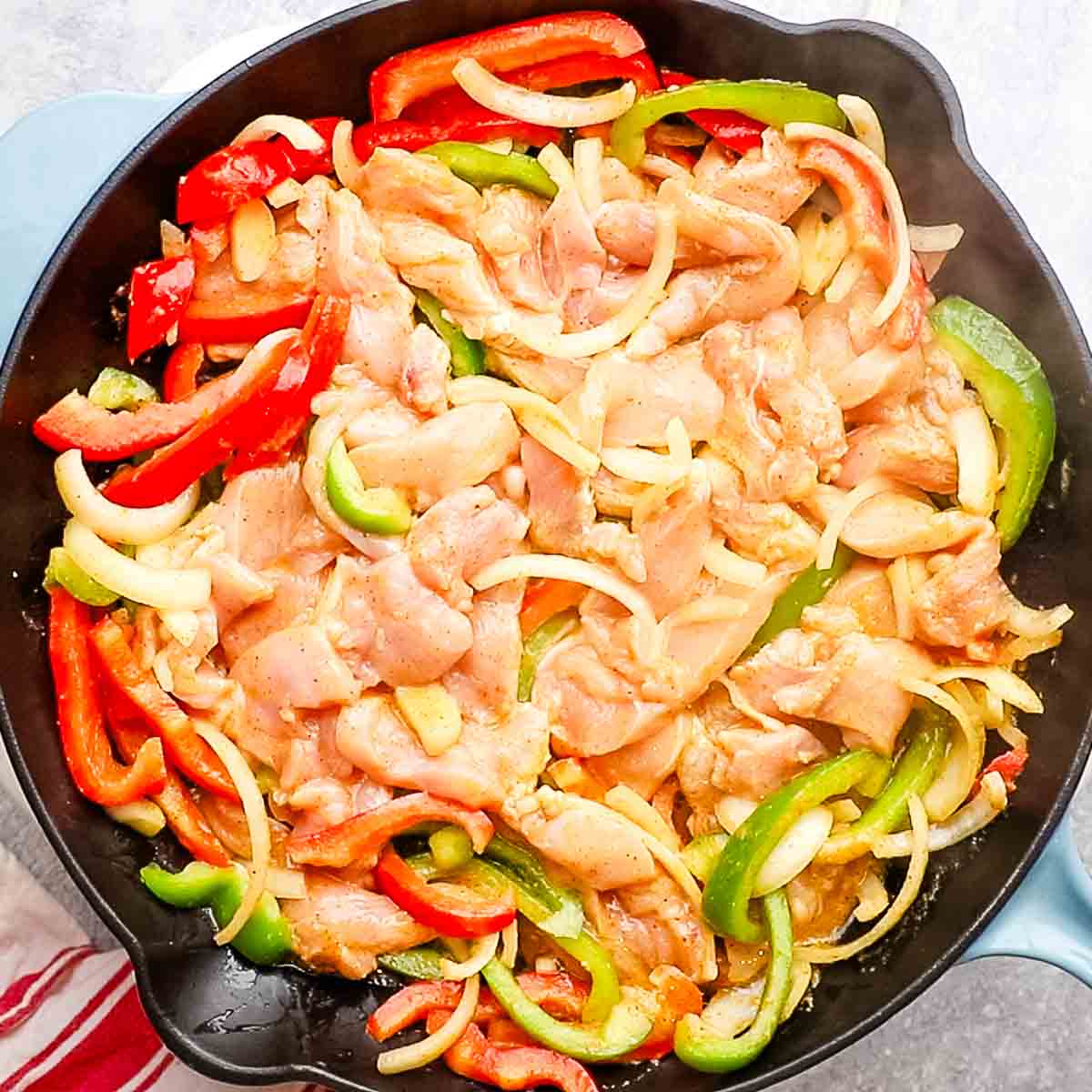 cooking chicken fajitas on a cast iron skillet