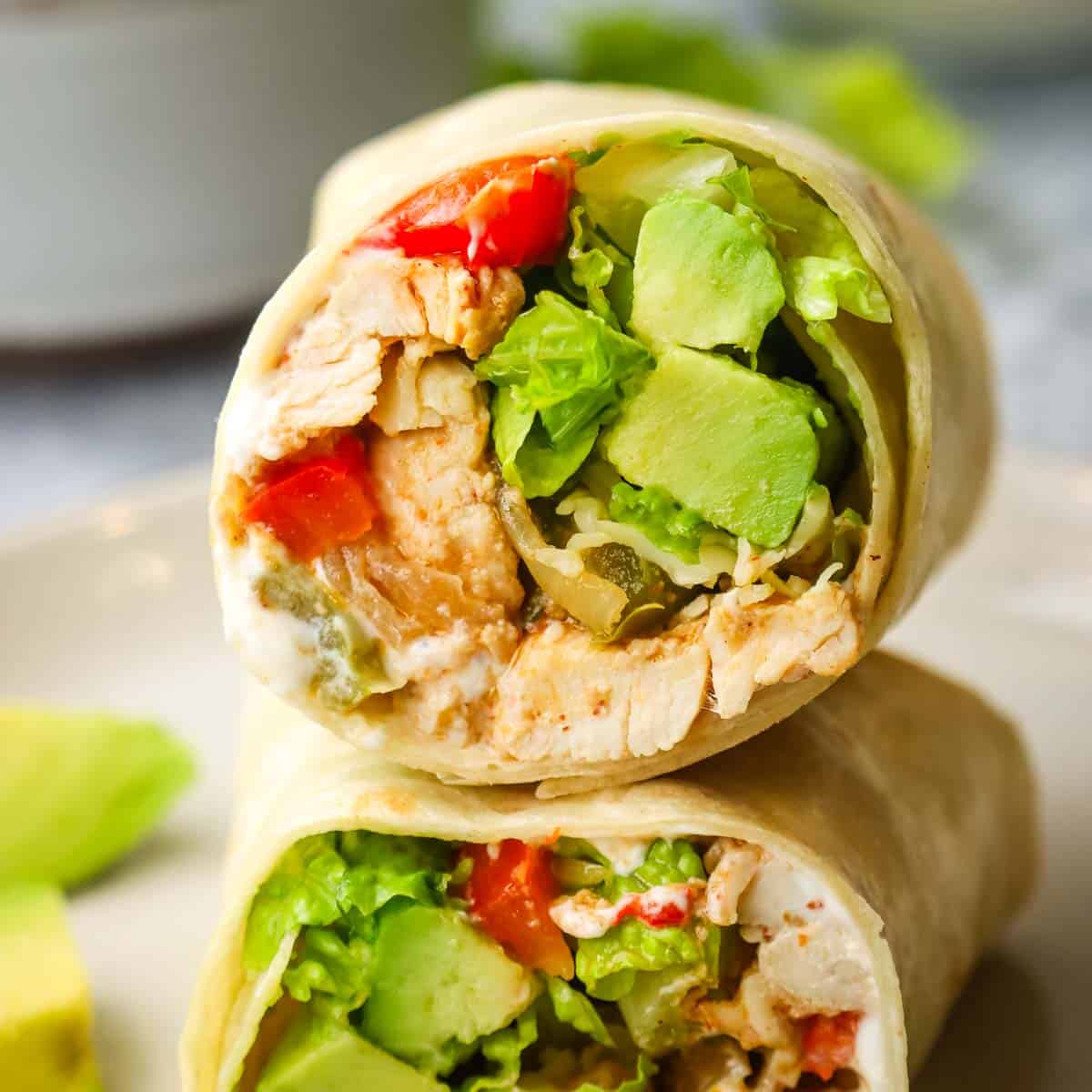 Two halves of a chicken fajita wrap stacked on top of each other to show the filling.