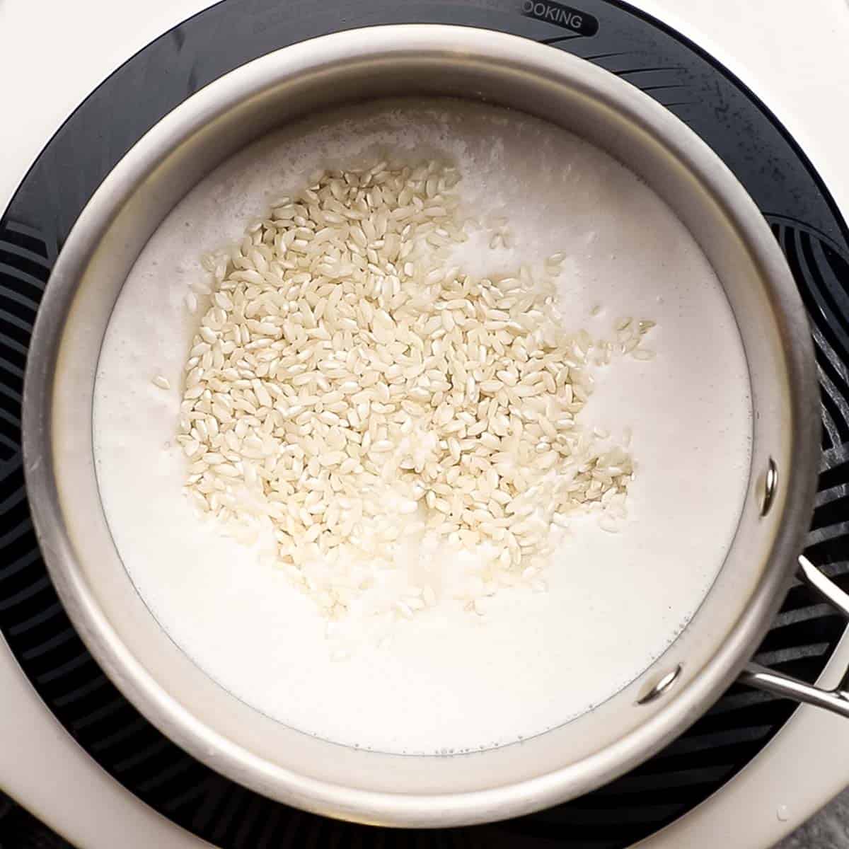 milk mixture and rice simmering in a medium saucepan