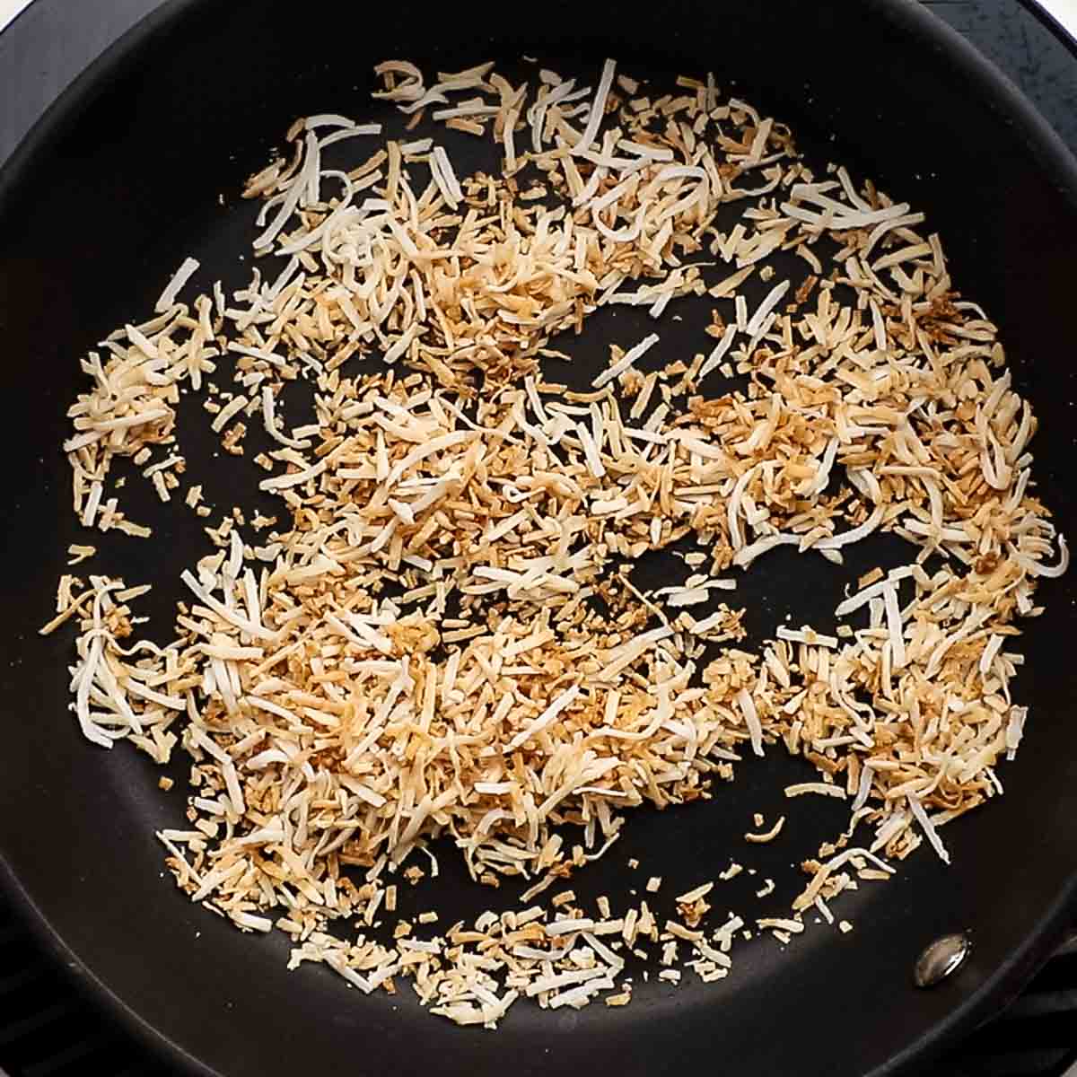 toasting coconut flakes in a pan