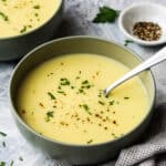 a bowl of potato leek soup with a spoon in it