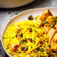 yellow basmati rice served in a plate with a curry