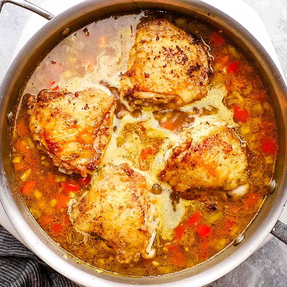 adding chicken thighs to the skillet