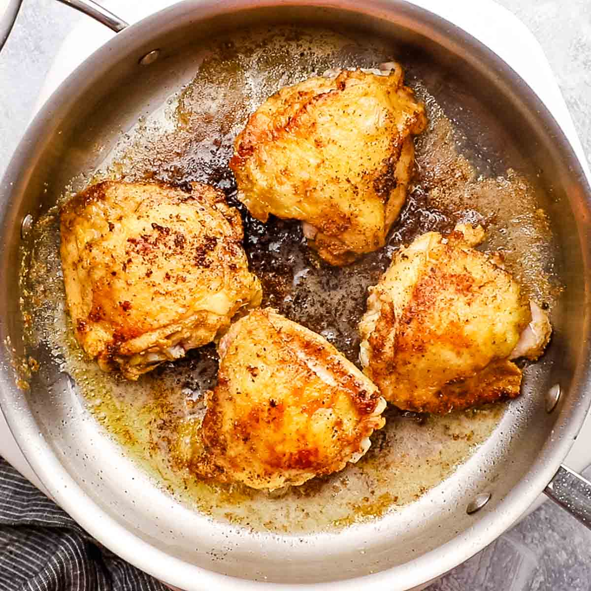 browned chicken thighs in a pan