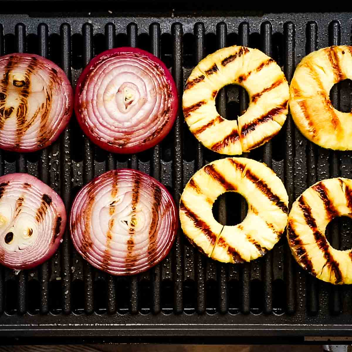 grilling red onions and pineapple on a grill
