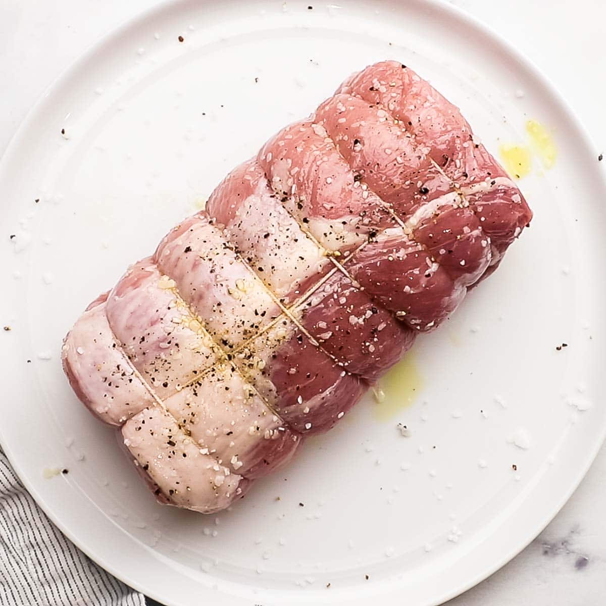 pork loin tied with strings and sprinkled with salt, pepper, and olive oil