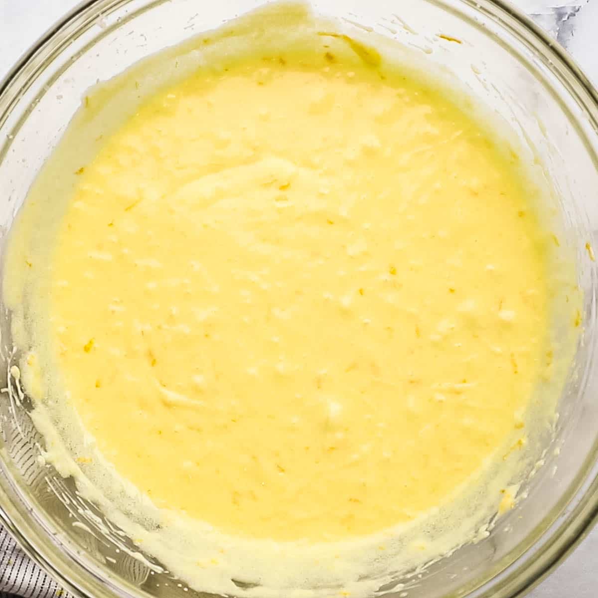 wet batter for the orange layer cake prepared in a bowl