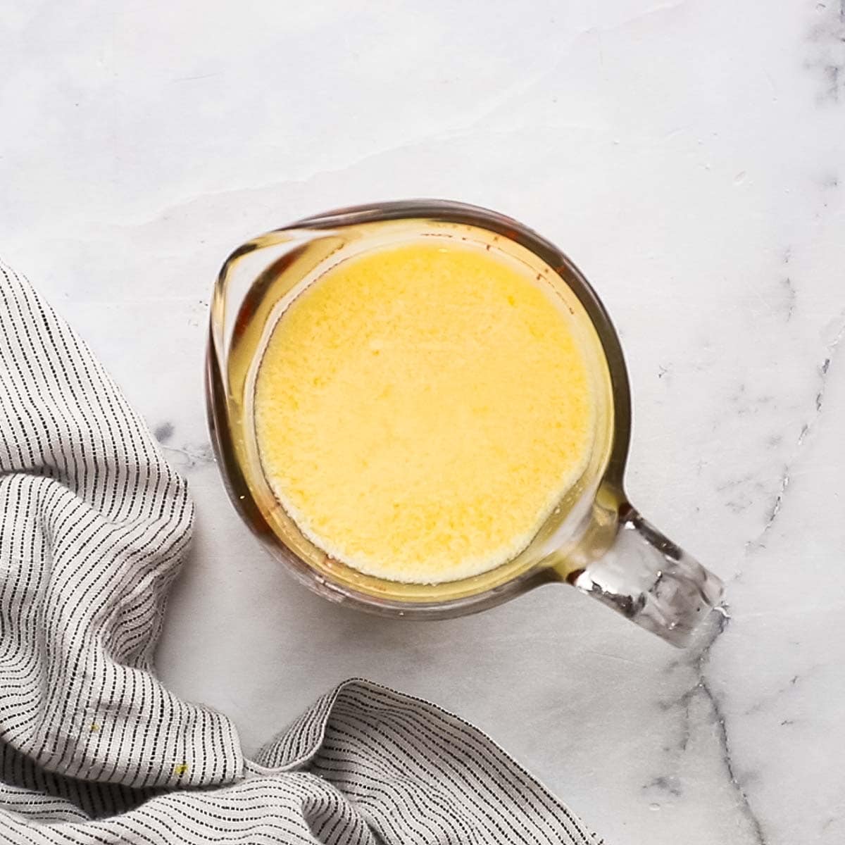 orange juice and milk mixed together in a measuring cup