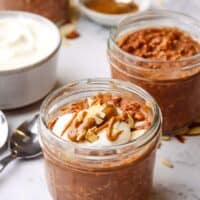 A mason jar of chocolate overnight oats topped with yogurt and almonds.