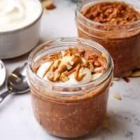 A mason jar of chocolate overnight oats topped with yogurt and almonds.