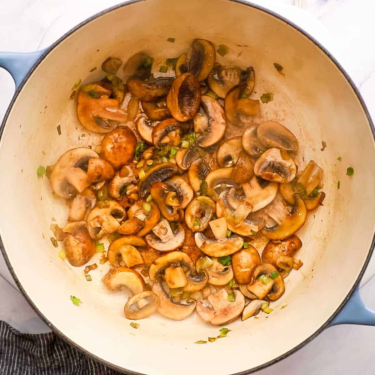mushrooms being sauteed in a pot