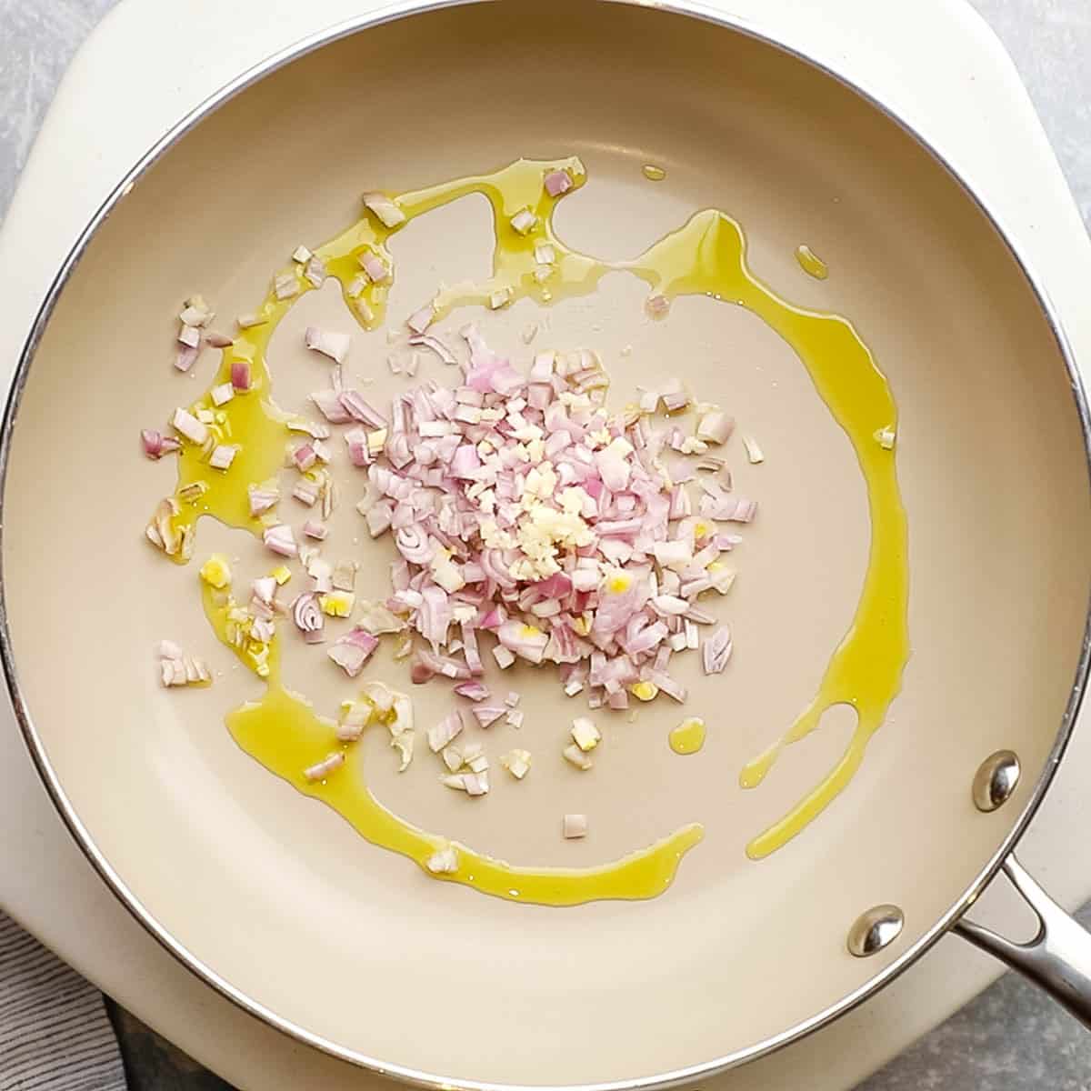 shallots and garlic added to a pan with some olive oil