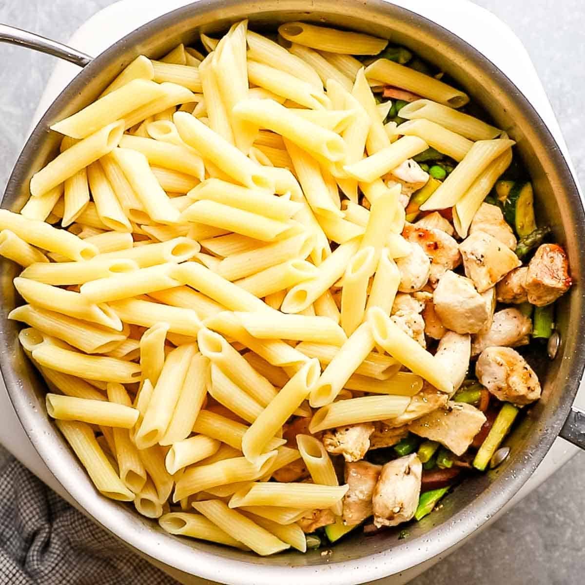cooked chicken and pasta added to the skillet