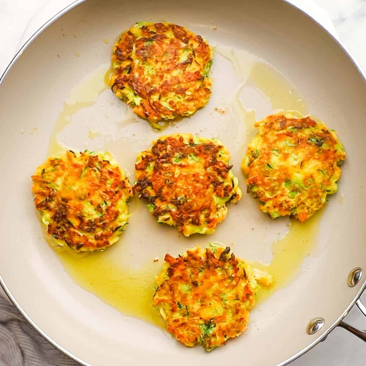 golden brown vegetable fritters in a pan