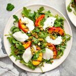 dressed greens topped with grilled peaches, fresh mozzarella, and nuts