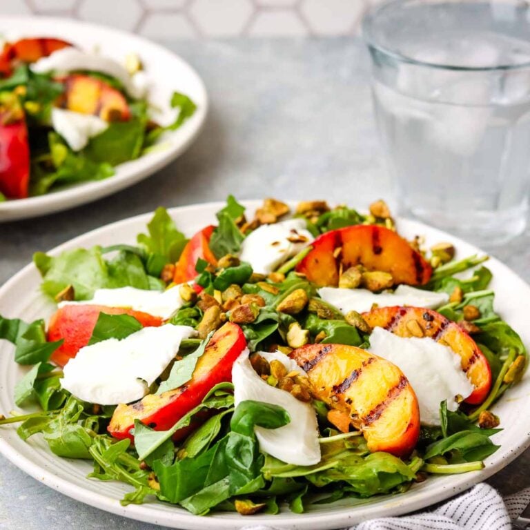 A plate of grilled peach salad with mozzarella.