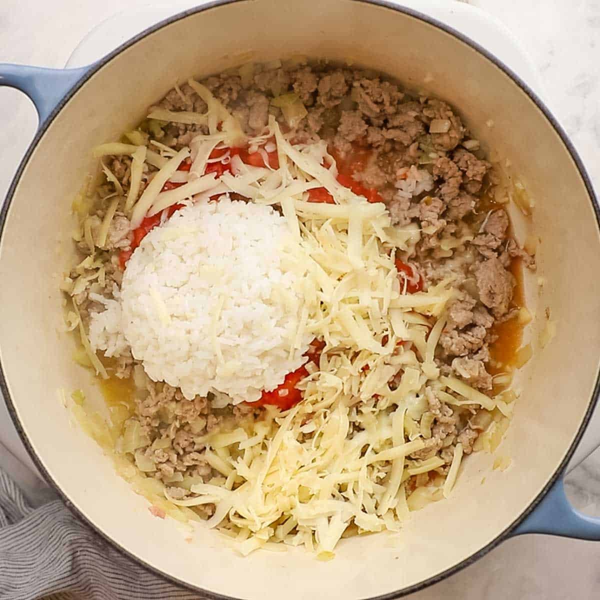 rice, cheese, tomatoes, and spices added to the pot