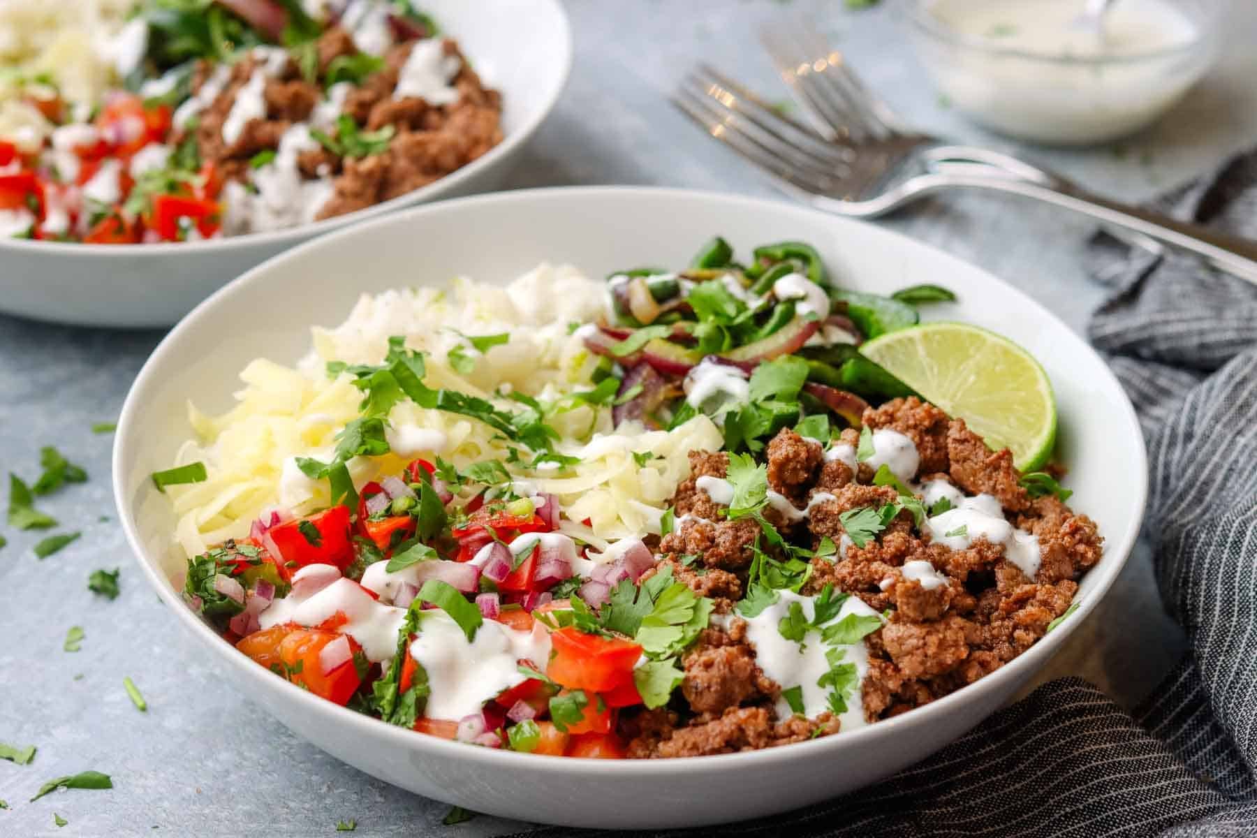 a rice bowl with ground beef, pico de gallo, sour cream, and cheese.