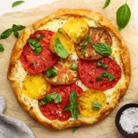 An heirloom tomato and ricotta tart garnished with fresh basil.