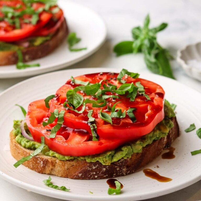 a slice of tomato avocado toast on a plate.