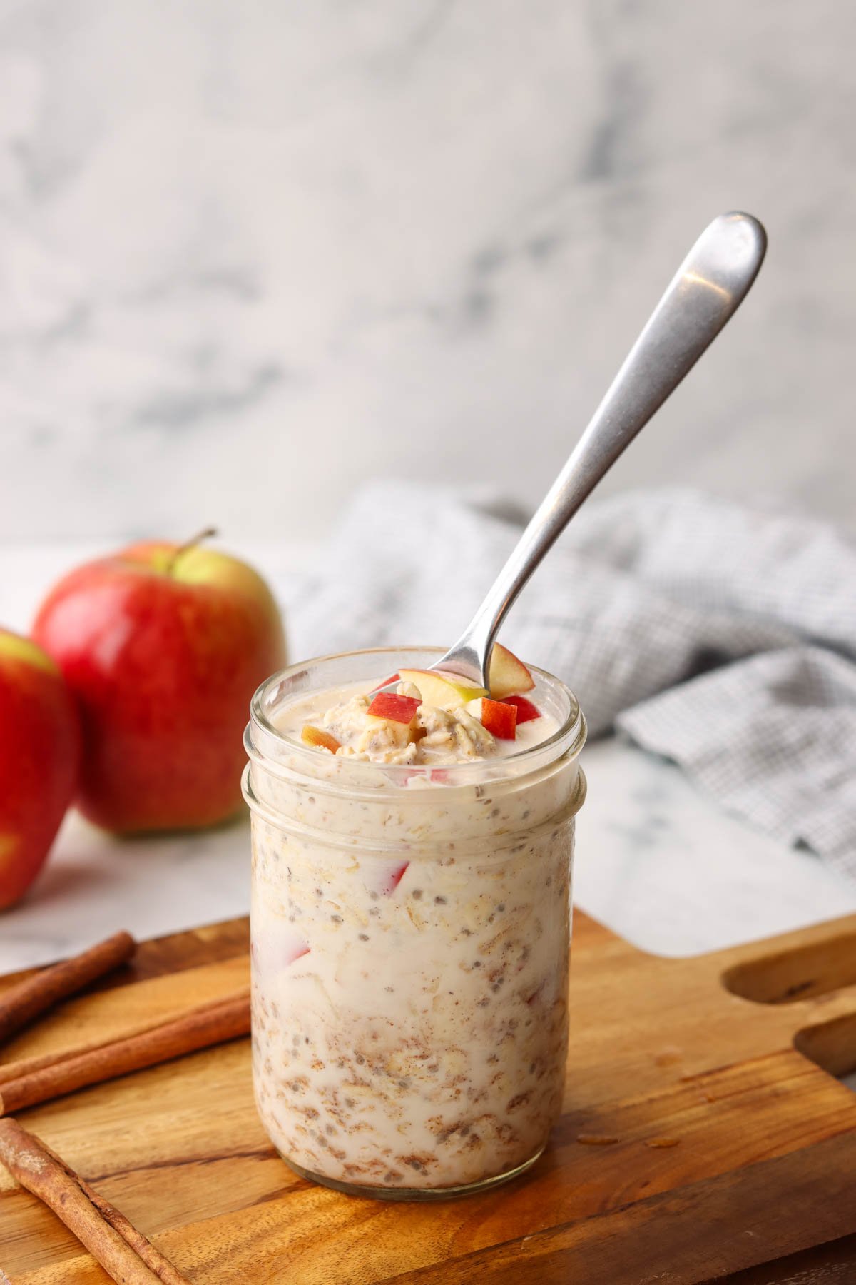 a jar of apple cinnamon overnight oats with a spoon in it