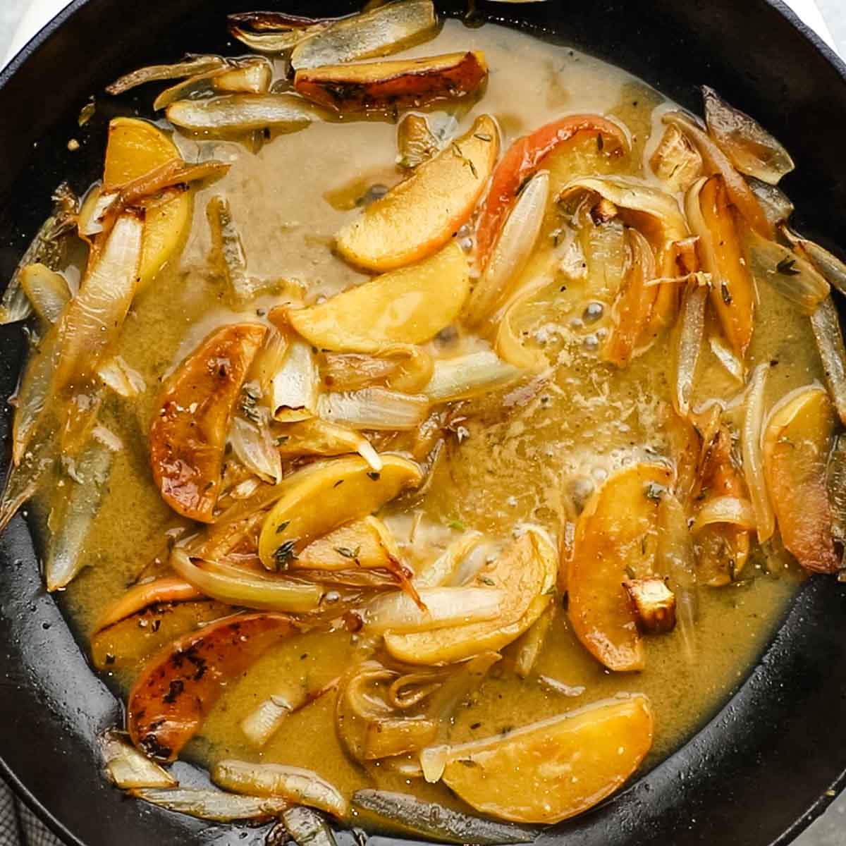 apples and onions cooking in the pan with rest of the ingredients