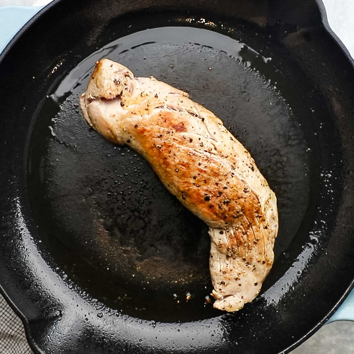 browning pork tenderloin in a skillet