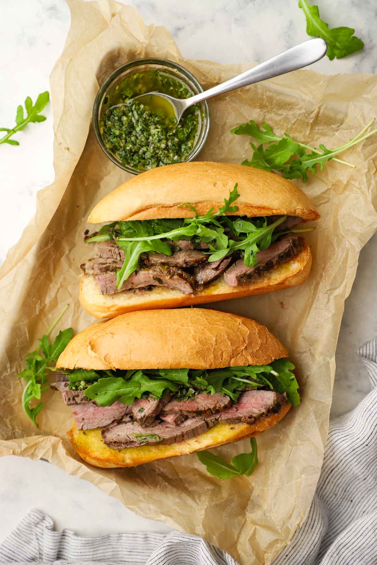 overhead view of two steak sandwiches with chimichurri