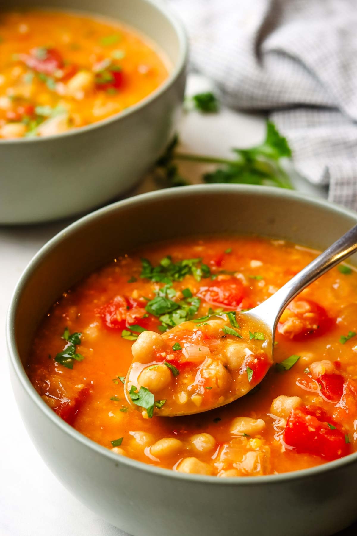 a bowl of lentil and chickpea soup with a spoon in it