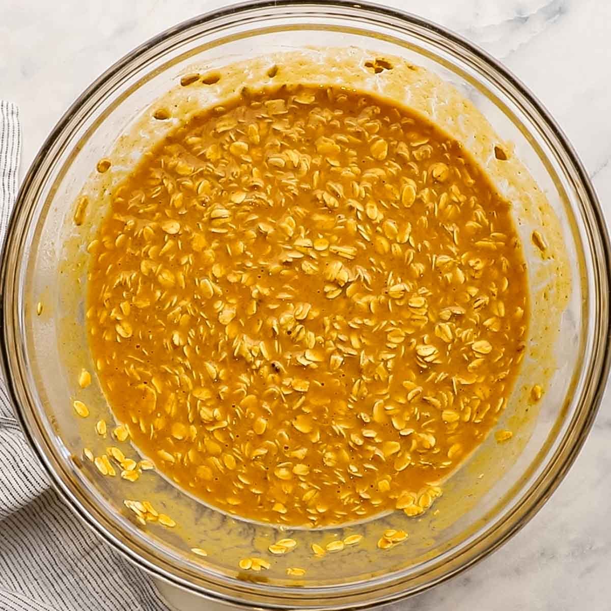 oats mixed together with wet ingredients in a bowl